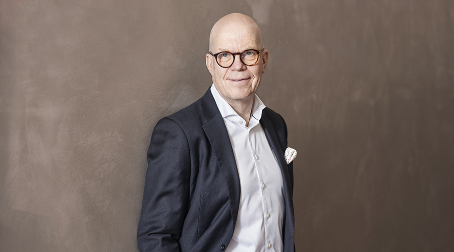 Esa Kallio seinän vieressä seisomassa.